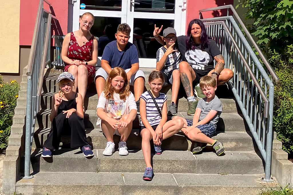 Die Teilnehmergruppe des Projekts „Sozialraum Kids“ sitzt gemeinsam auf einer Treppe vor dem SJZ Zingst.