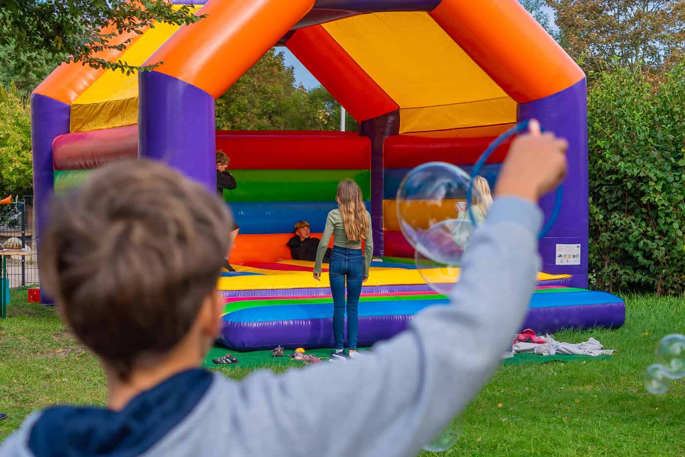Kinder spielen auf einer bunten Hüpfburg im Freien in Zingst.